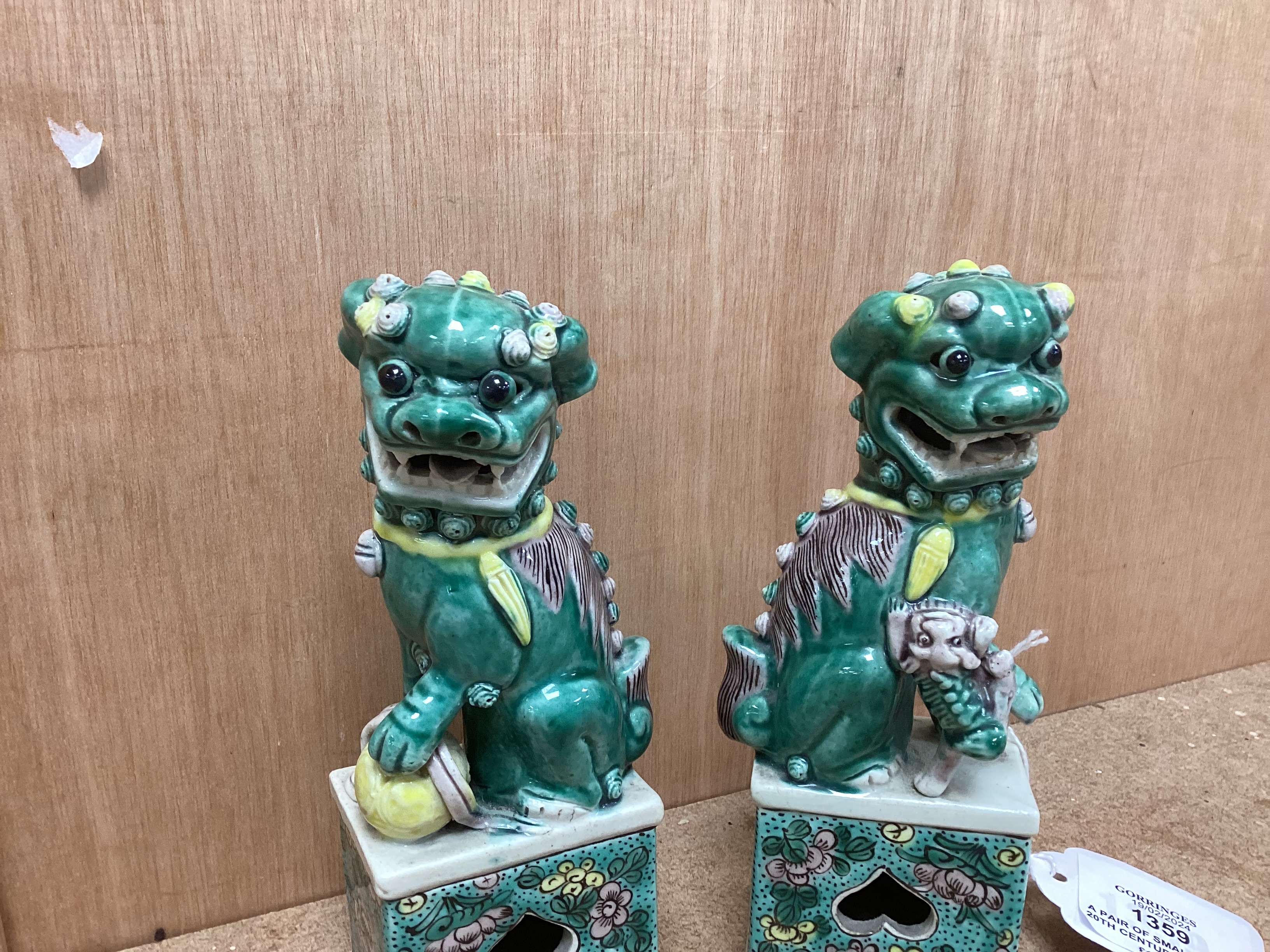 A pair of small early 20th century Chinese figures of Buddhist lions, 15.5cm high